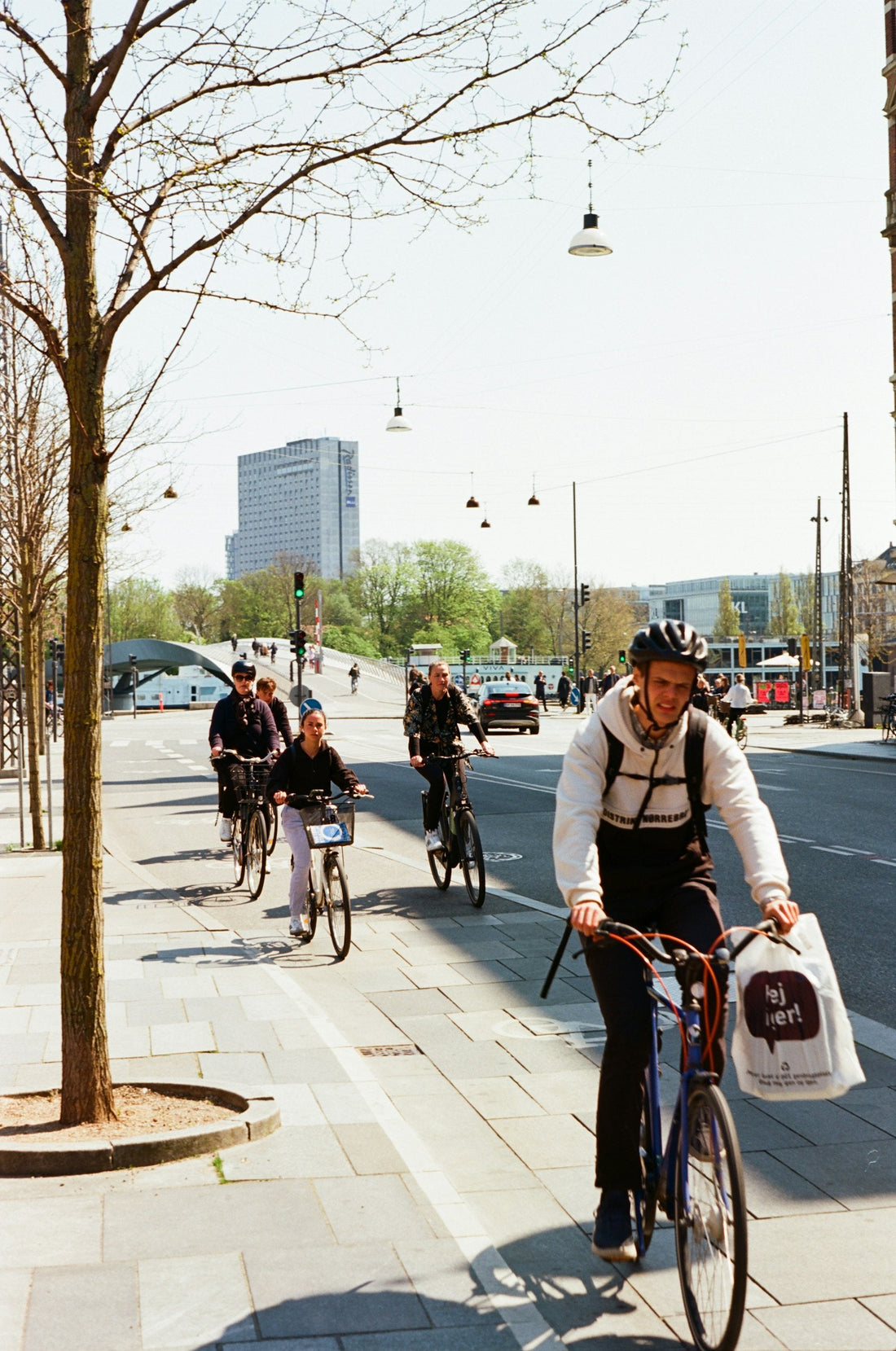A group of people riding bicycles together down a city street
